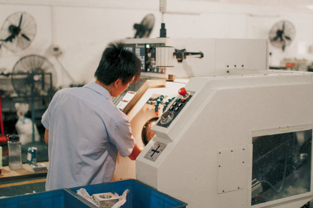 Production worker operating manufacturing equipment for custom travel products